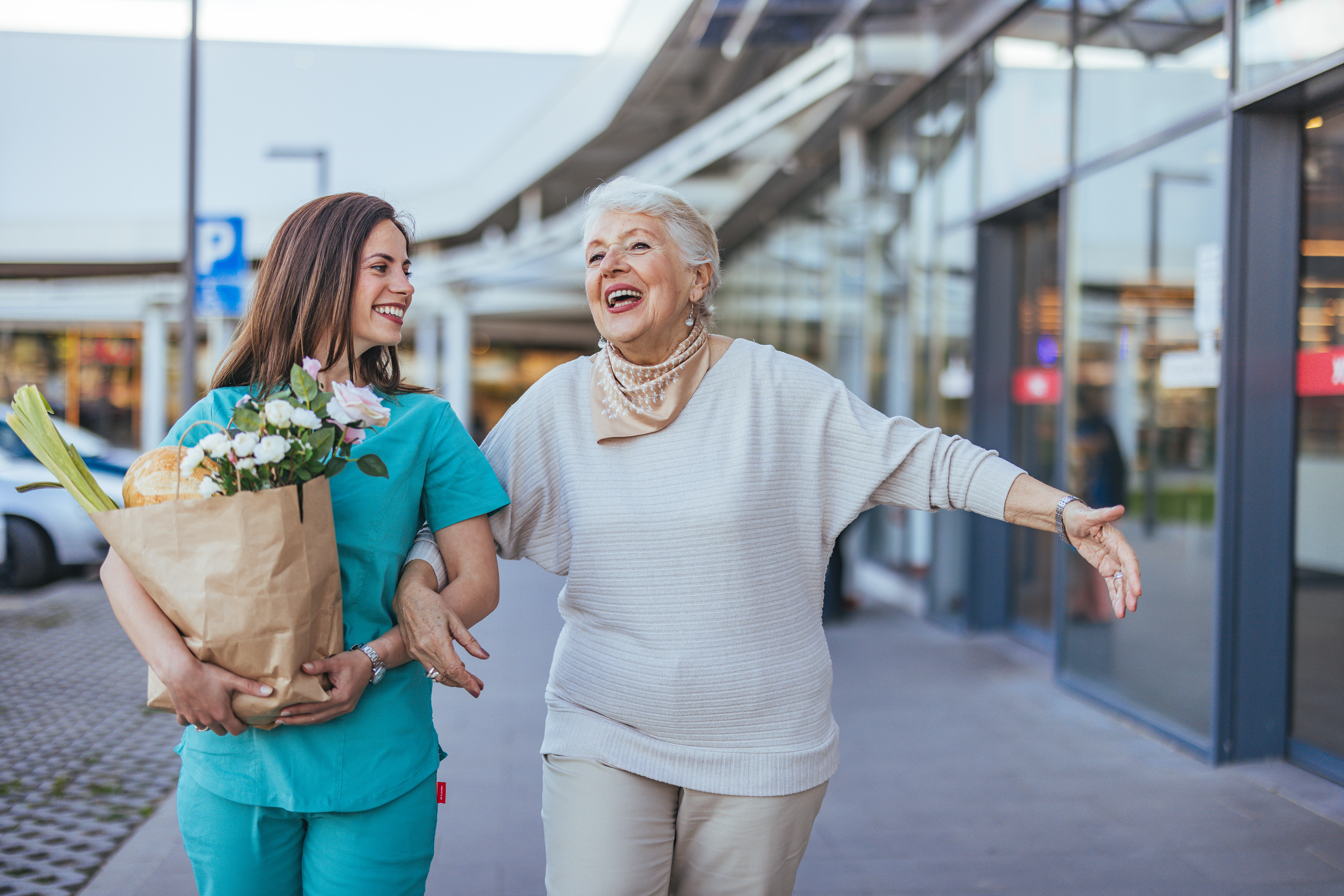 A female caregiver helps an elderly female patient with grocery shopping.